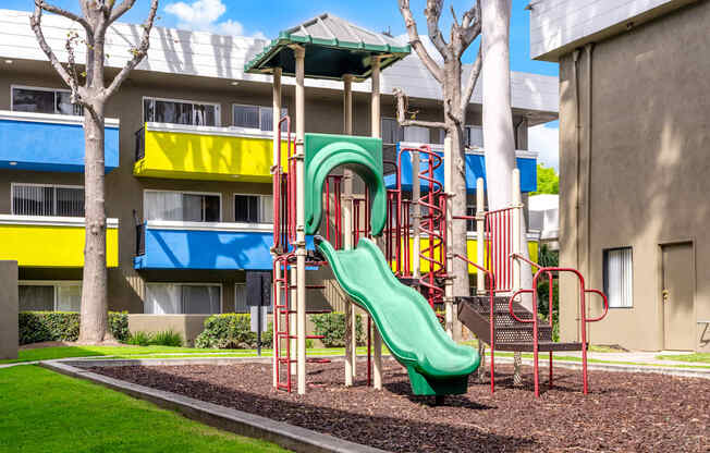 a playground in front of a building with a slide