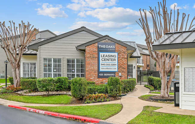 The Oaks Leasing Center is a brick building with a sign on the front.