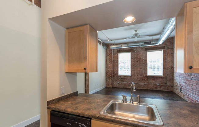 an empty kitchen with a sink and a window at Mayton Transfer Lofts, Petersburg, VA 23803