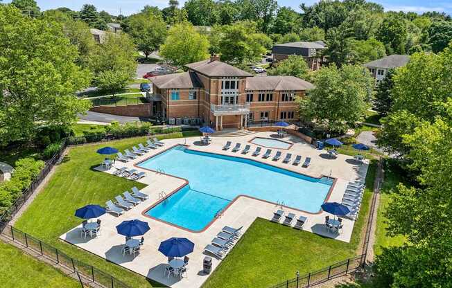 A large swimming pool surrounded by lawn chairs and umbrellas.