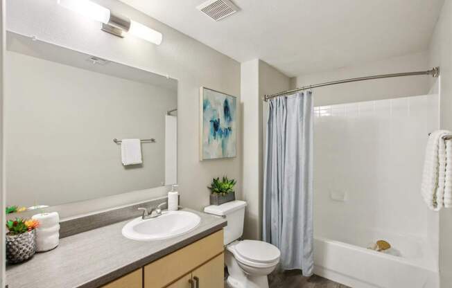 A bathroom with a white sink and a white toilet.