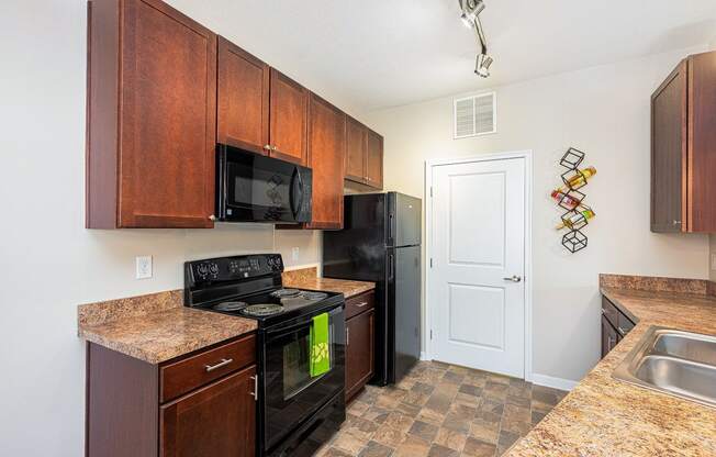 a kitchen with black appliances and granite counter tops