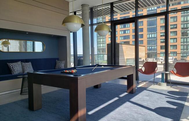 a pool table in a room with large windows at The Lively, Jersey City