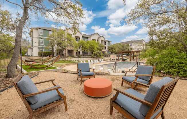 A backyard with a fire pit and chairs.