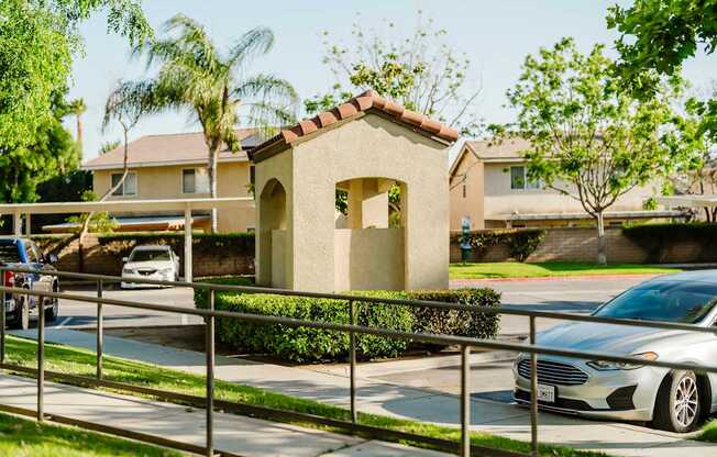 A small building with a tiled roof is surrounded by a metal fence.