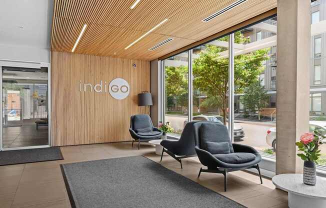 Indigo logo on a wooden wall above a grey chair.