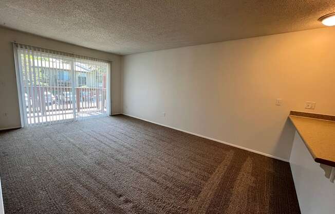 an empty living room with a sliding glass door