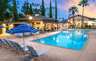 A poolside area with lounge chairs and umbrellas.