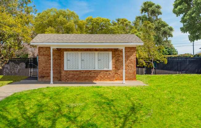 a small brick building with a lawn in front of it