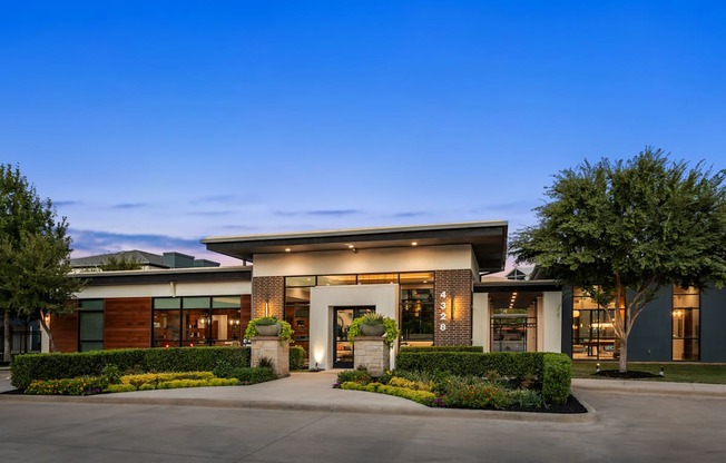 A modern building with a large front yard and a clear blue sky above.