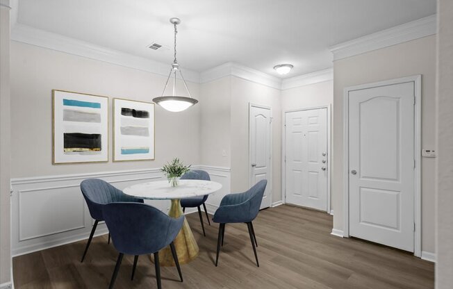 A dining room with a white table and blue chairs.