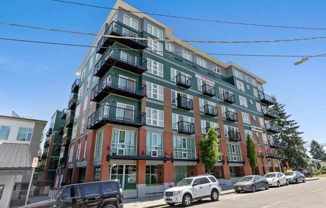 Multi-story property building on the street with cars parked in front of it at Sedona Apartments, Seattle, WA