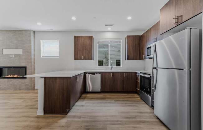 Modern kitchen with a stainless steel refrigerator and wooden cabinets at Thrive at Green Mountain, Camas, WA, Washington