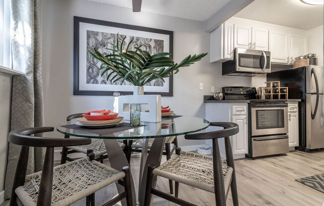 a kitchen with a glass table with three stoolsat Sunnyvale Crossings Apartments, LLC, Sunnyvale California