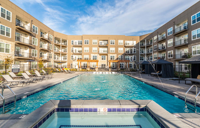 a swimming pool with an apartment building in the background