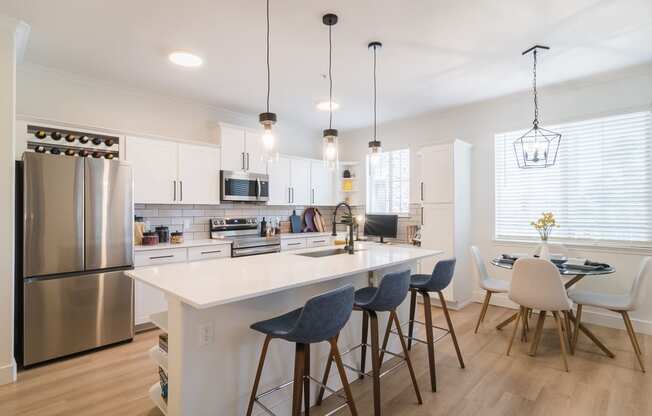 a kitchen with a large island and a dining table with chairs