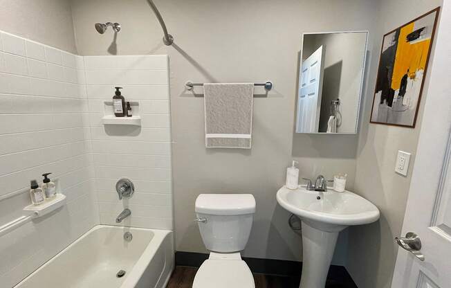 A white toilet sits next to a white sink in a small bathroom.