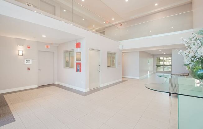 A white hallway with a glass table and chairs at Woodley Sara Apartment, Van Nuys, California