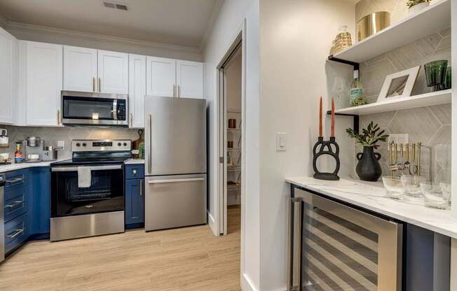 A kitchen with a refrigerator, oven, and microwave.