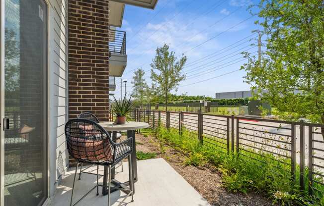 a patio with a table and a chair on a balcony