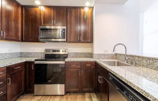 a kitchen with wooden cabinets and granite counter tops and stainless steel appliances