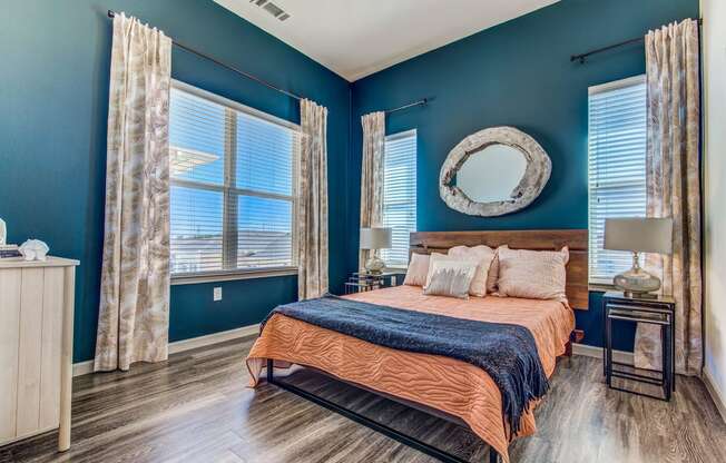 Hebron 121 Station Lewisville Apartments - Spacious Bedroom with Stylish Decor, Wood-Style Flooring, Large Windows, and Two-Toned Walls