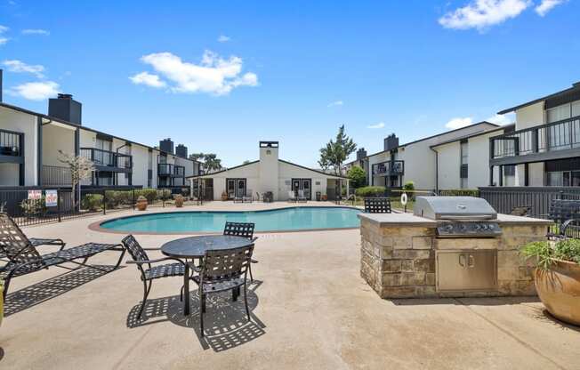 our apartments have a large pool and patio with chairs and tables