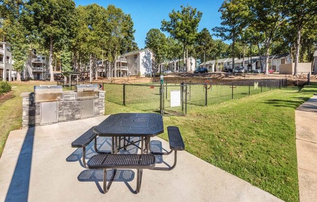 a picnic table in a park next to a dog park