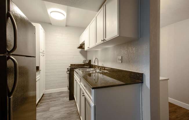 a kitchen with white cabinets and a stainless steel refrigerator