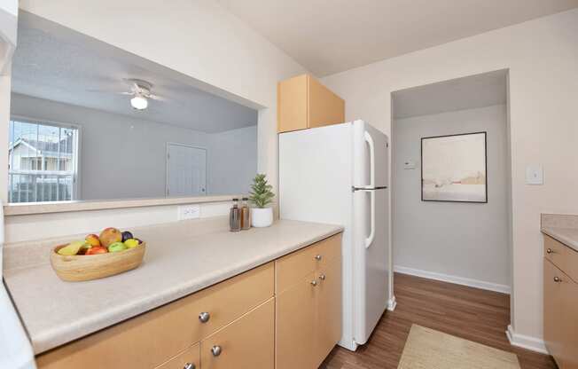 a kitchen with a white refrigerator and a basket of fruit at Vineyard Terrace Apartments, California