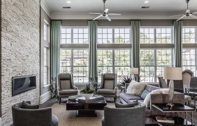 a living room with large windows and a couch and chairs