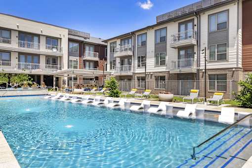 A swimming pool in front of apartment buildings.