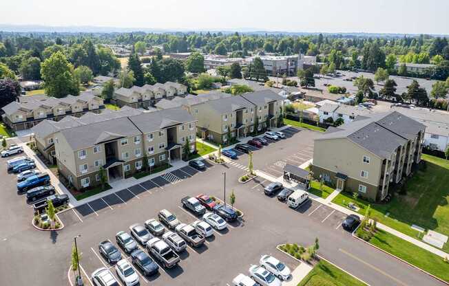 A parking lot with cars and apartment buildings in the background.