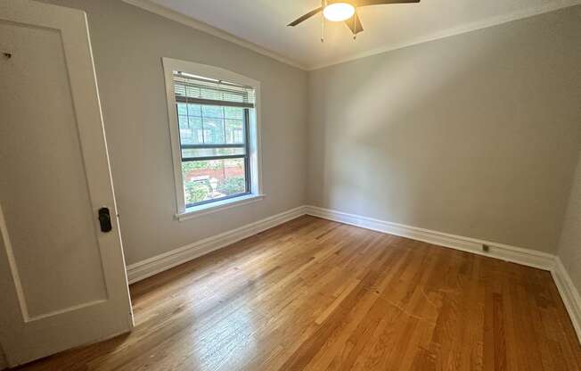 a living room with wood floors and a ceiling fan