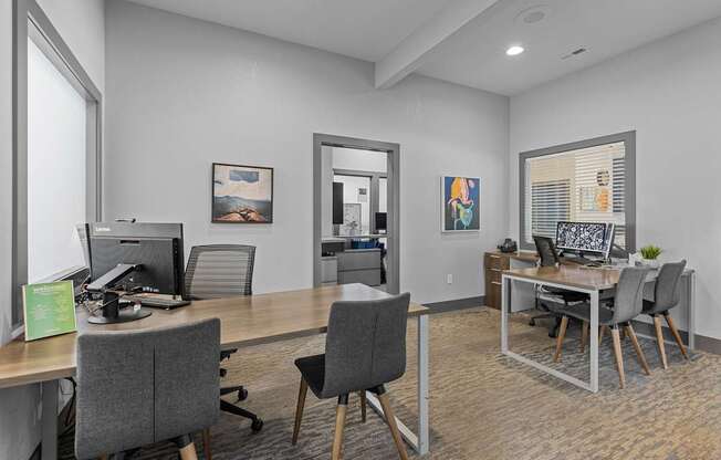 an office with desks and chairs and a desktop computer