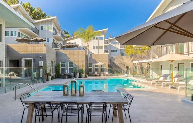 a table and chairs next to a swimming pool