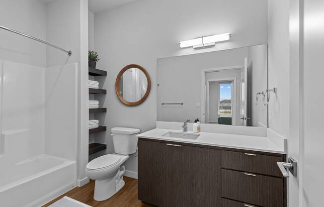 a bathroom with a toilet sink and shower and a mirror