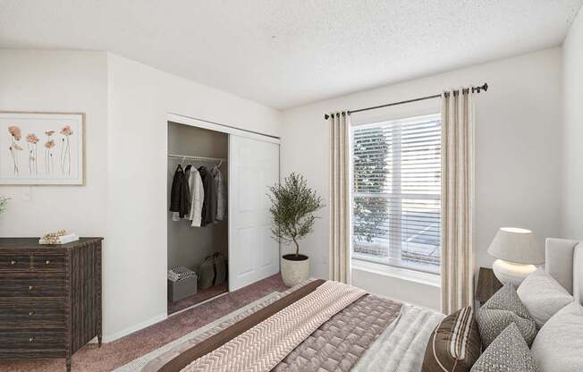 A bedroom with a bed, dresser, and window.