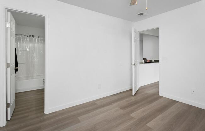 A room with a white wall and a wooden floor.