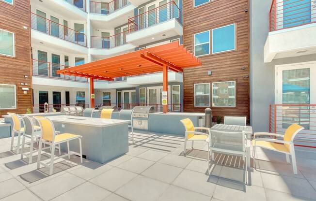 A patio with a table and chairs and a red umbrella.