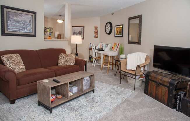 a living room with a couch and a tv and a dining room table
