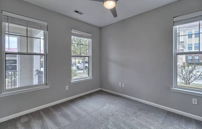 the living room of an empty home with two windows at Nexus at Sandhill, Columbia South Carolina