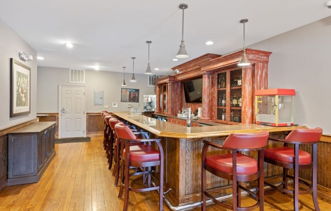 a large bar in a kitchen with red bar stools