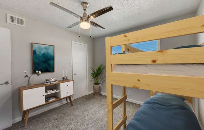 a bedroom with a bunk bed and a nightstand with a plant