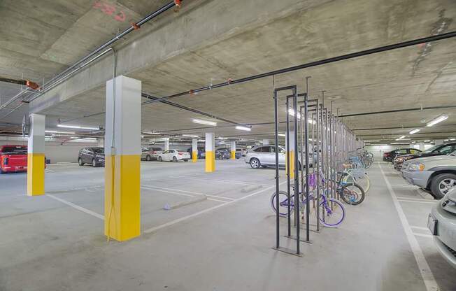 A parking garage with a yellow pole and bicycle rack at Woodley Sara Apartment, Van Nuys, CA, 91406