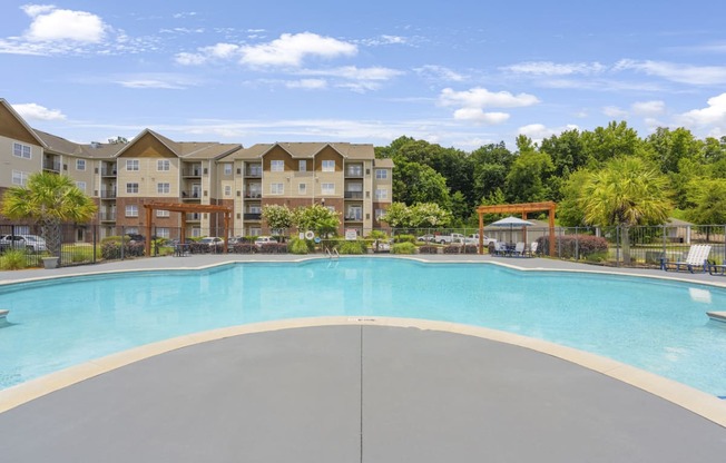 a swimming pool with an apartment building in the background