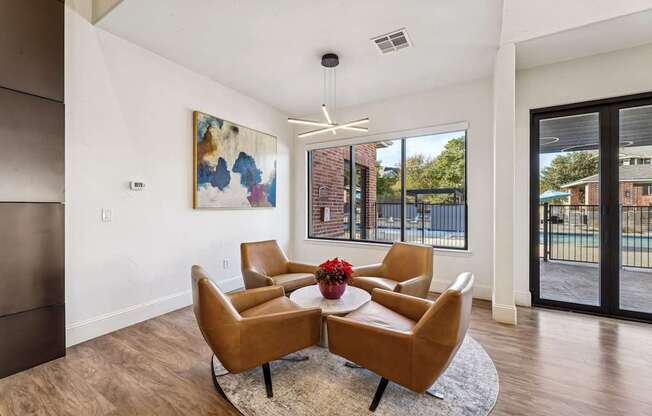 A living room with a brown chair and a painting on the wall.