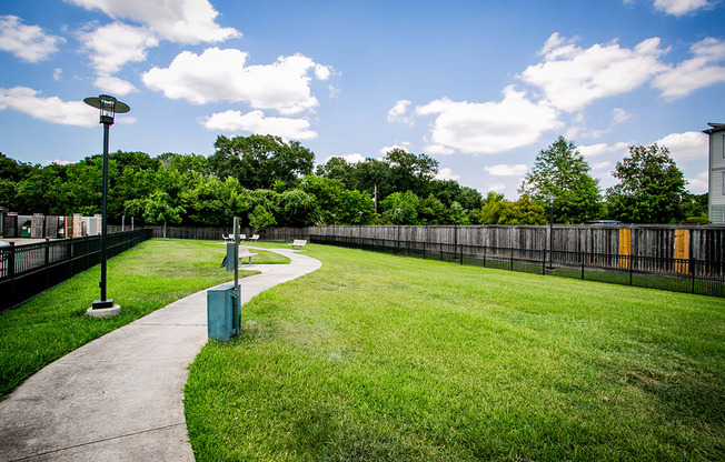 a park with a grassy area and a fence