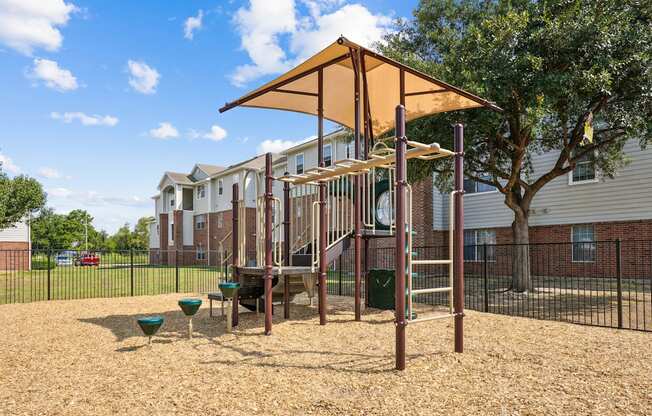 our apartments have a playground with a playset and a tree