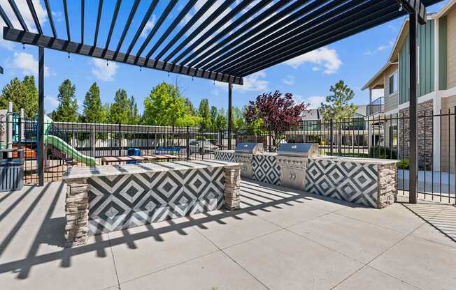 A playground with a black and white patterned bench under a black and white striped awning.